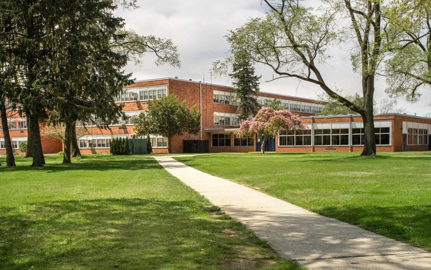 CBSE school campus building with green lawn and walkway