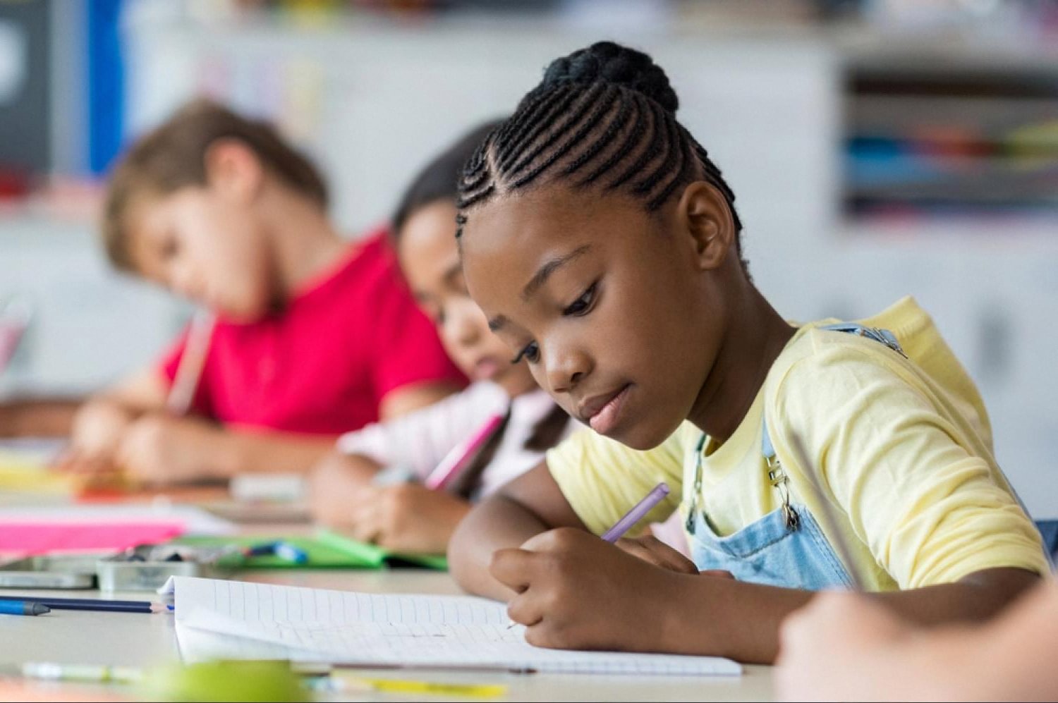 Young CBSE school student writing in a notebook during class in the UAE